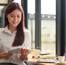 Calm asian woman sitting in coffee shop and reading book.