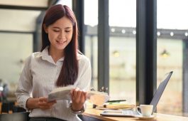 Calm asian woman sitting in coffee shop and reading book.